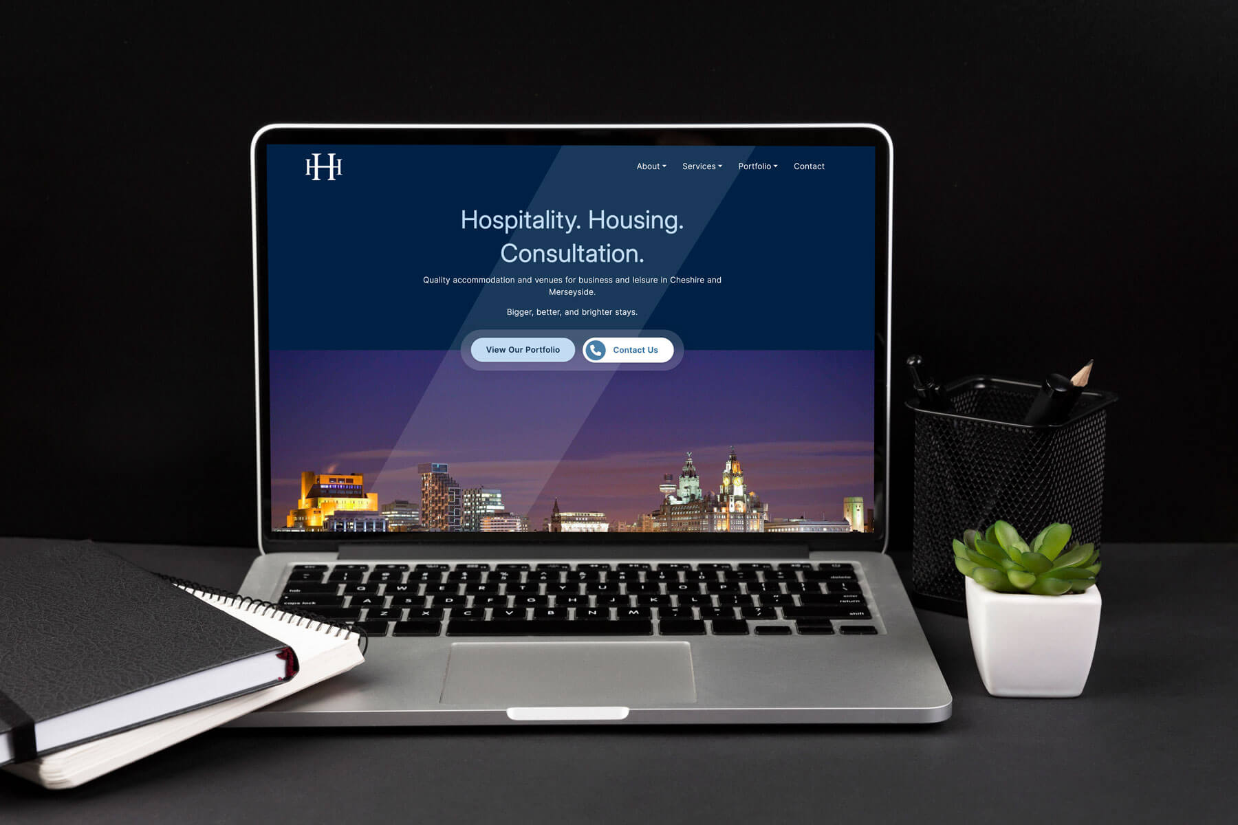 Laptop displaying the top section of the Hillcrest Hotels homepage