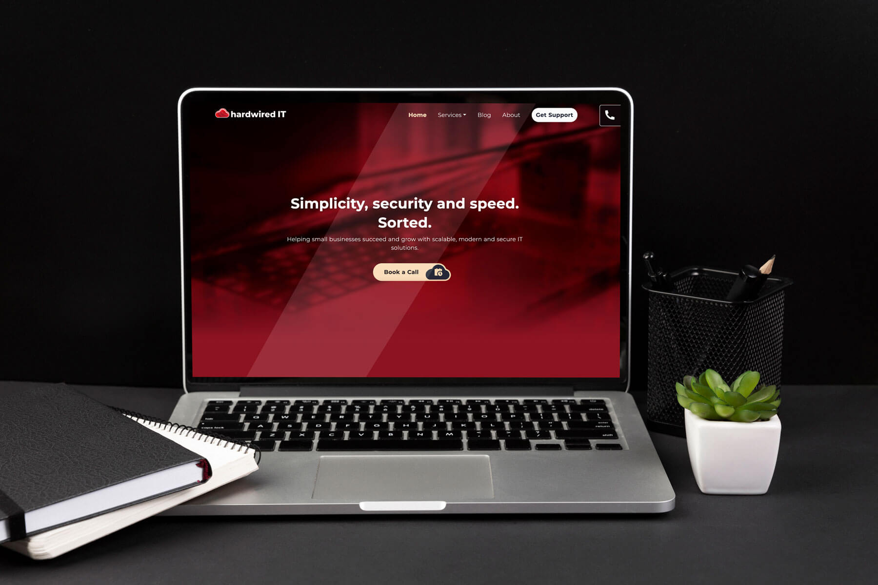 Laptop displaying the top section of the Hardwired IT homepage